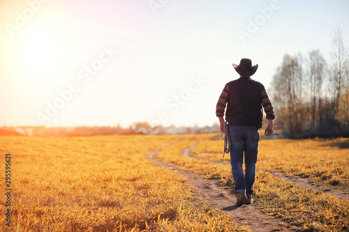 Fotografija A man cowboy hat and a loso in the field