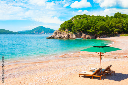 Beautiful beach with chaise lounges near Budva, Montenegro. Travel destination, popular touristic resort photo