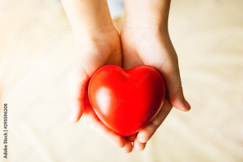 child hands holding red heart, health care, donate and family insurance concept child hands holding red heart, health care, donate and family insurance concept