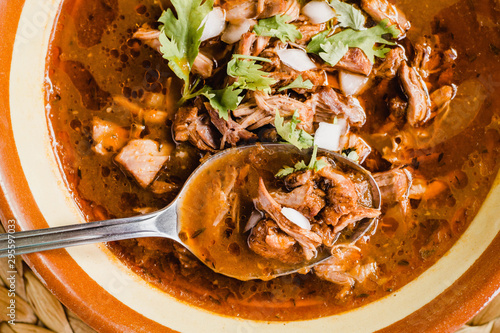 Traditional birria de res, a Jalisco style beef soup typical from Mexico. Close-up of the stew with a spoon photo