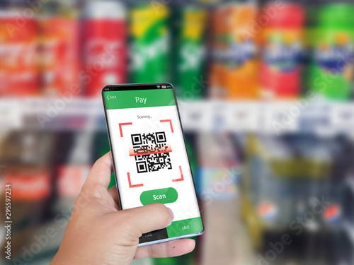 Hand holding smartphone to scan QR code payment , online shopping , cashless concept.