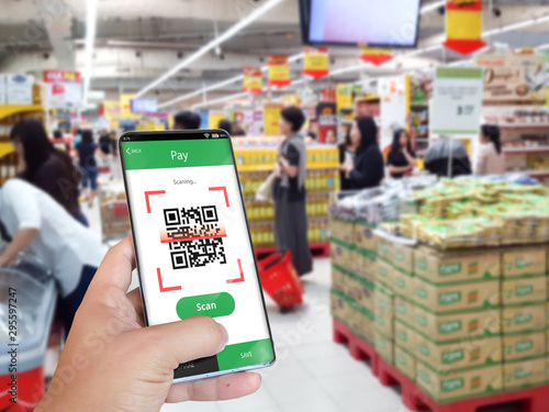 Hand holding smartphone to scan QR code payment , online shopping , cashless concept.