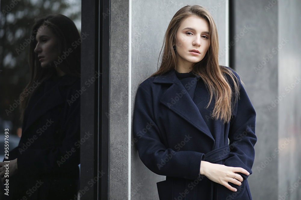 Beautiful girl in a coat in business downtown