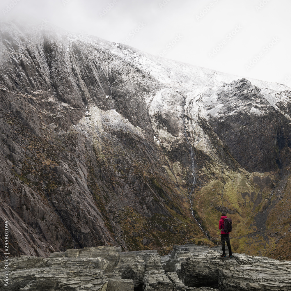 Stunning dramatic landscape image of snowcapped Glyders mountain range in Snowdonia during Winter with menacing low clouds hanging at the peaks Stunning dramatic landscape image of snowcapped Glyders mountain range in Snowdonia during Winter with menacing low clouds hanging at the peaks