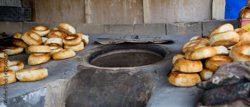 Taditional Kyrgiz local bakery oven with fresh bread of tandyr nan aside. photo