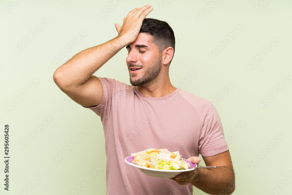 Young handsome man with salad over isolated green wall has realized something and intending the solution Young handsome man with salad over isolated green wall has realized something and intending the solution