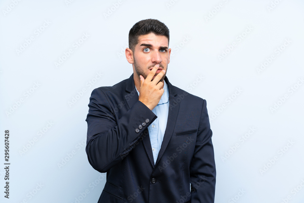 Handsome man over isolated blue background surprised and shocked while looking right Handsome man over isolated blue background surprised and shocked while looking right