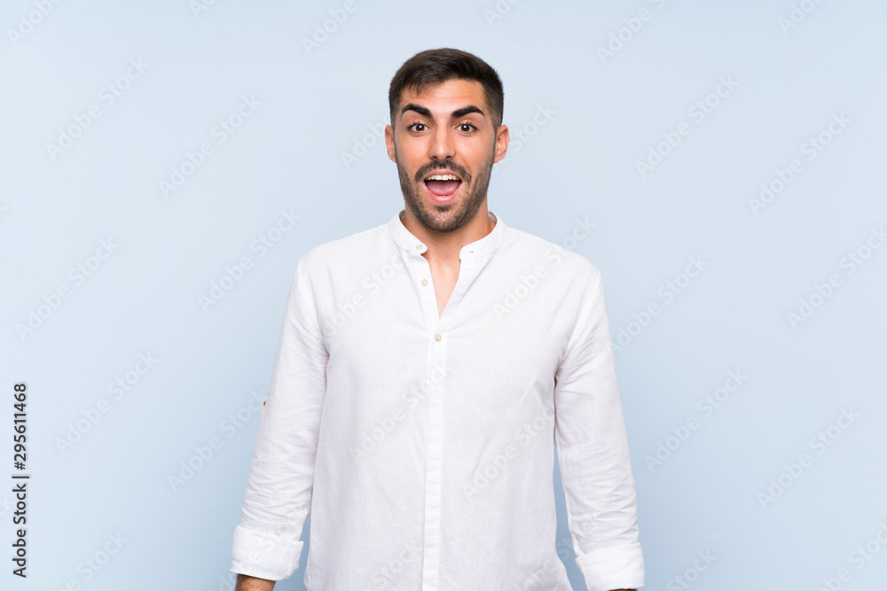 Handsome man with beard over isolated blue background with surprise facial expression Handsome man with beard over isolated blue background with surprise facial expression