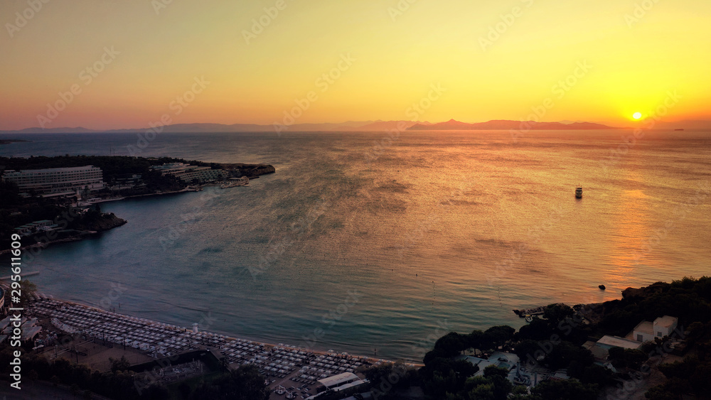 Aerial drone photo of iconic Astir or Asteras celebrity beach featuring ancient Apollo Zoster Temple in the heart of Athens Riviera with golden colours at sunset, Vouligameni, Attica, Greece