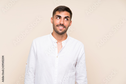 Handsome man with beard over isolated background laughing and looking up