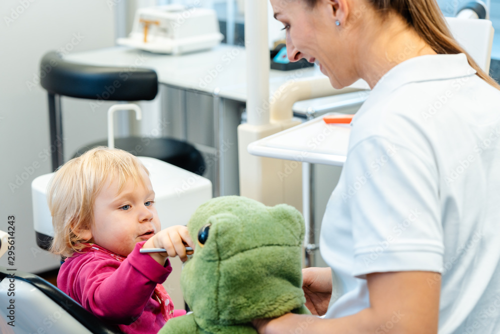 Little child in dentists surgery learning how to brush teeth Little child in dentists surgery learning how to brush teeth