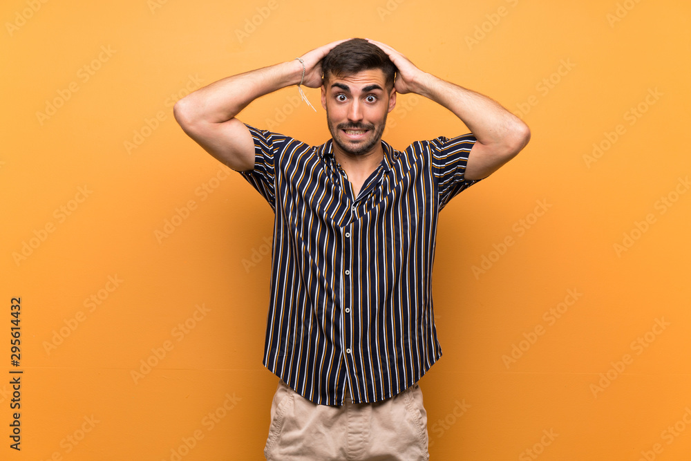 Naklejka premium Handsome man with beard over isolated background frustrated and takes hands on head