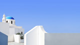 Santorini blue dome and whitewashed structures on light blue sky