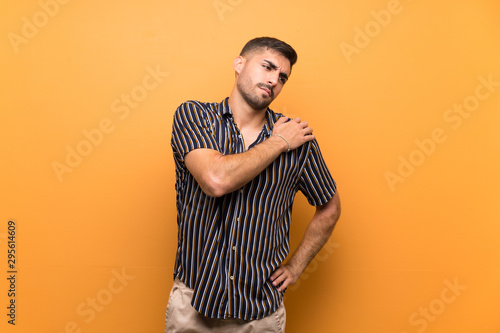 Handsome man with beard over isolated background suffering from pain in shoulder for having made an effort