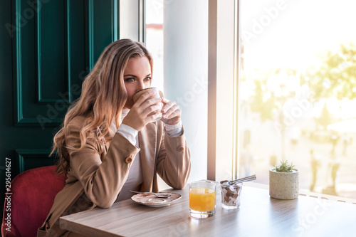 Beautiful young woman drinking coffee at cafe.