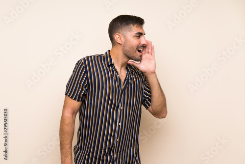 Handsome man with beard over isolated background shouting with mouth wide open