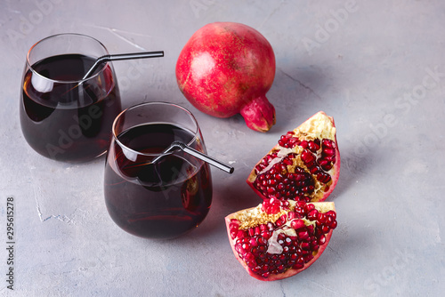 Two Glasses of Fresh Tasty Pomergranate Juice on Gray Background Diet Healthy Drink Detox Ripe Pomegranate Copy Space photo