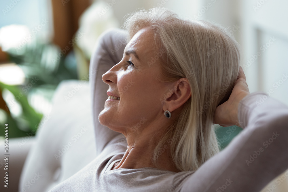 60s woman put hands behind head resting indoors enjoy weekend 60s woman put hands behind head resting indoors enjoy weekend