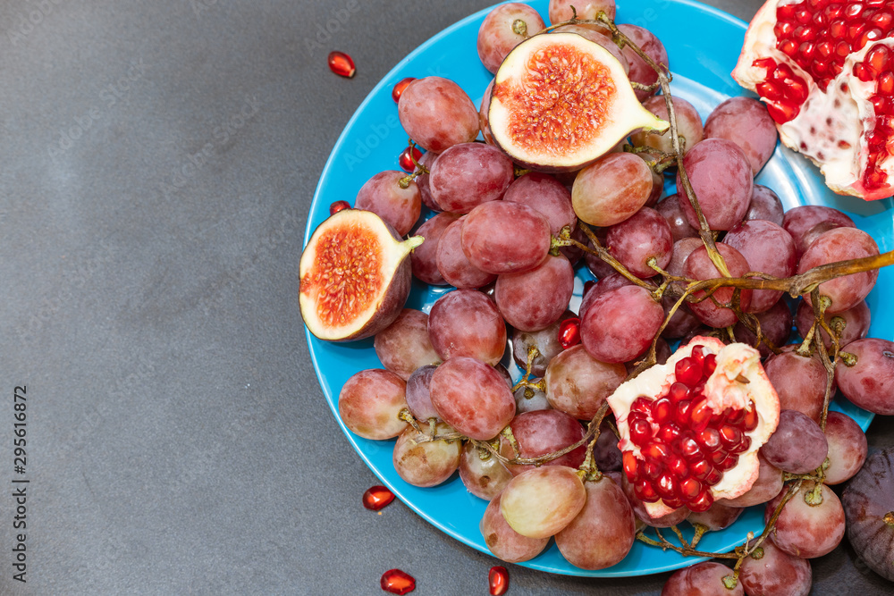 Grapes, figs and pomegranate on a dark background Grapes, figs and pomegranate on a dark background