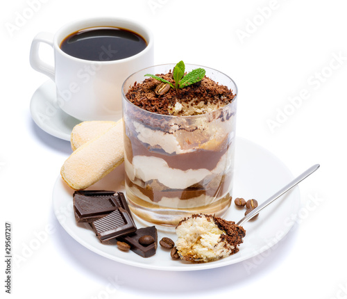 Classic tiramisu dessert in a glass, cup of coffee and pieces of chocolate on white background with clipping path