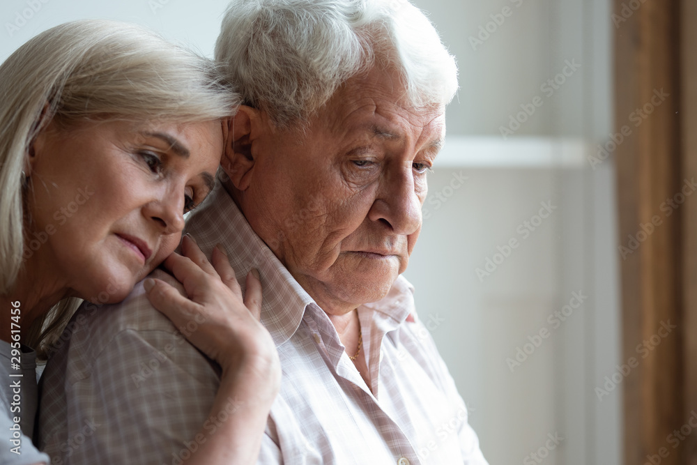 Middle-aged daughter snuggle to elderly father sharing his sorrows Middle-aged daughter snuggle to elderly father sharing his sorrows