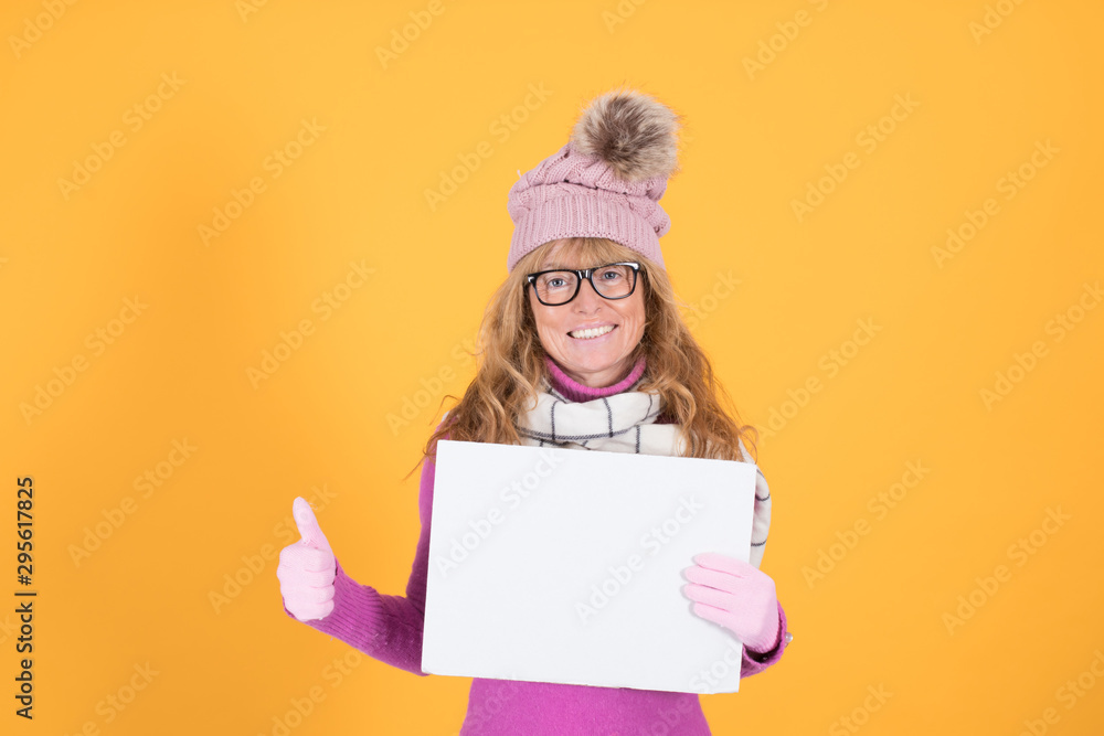 adult woman with warm clothes and poster on color background adult woman with warm clothes and poster on color background