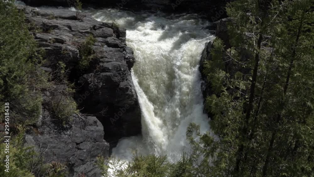 Drone shot of a large, gushing waterfall in the wilderness of the Gaspésie Mountains in Quebec, Canada. Drone shot of a large, gushing waterfall in the wilderness of the Gaspésie Mountains in Quebec, Canada.