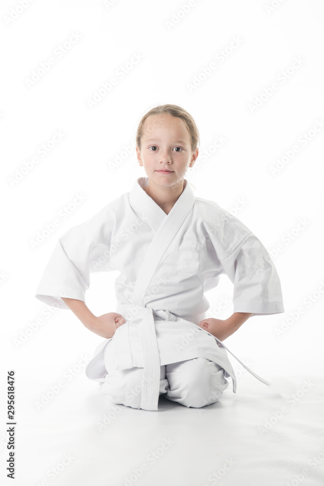 child practicing martial arts sitting on his knees in the gym child practicing martial arts sitting on his knees in the gym
