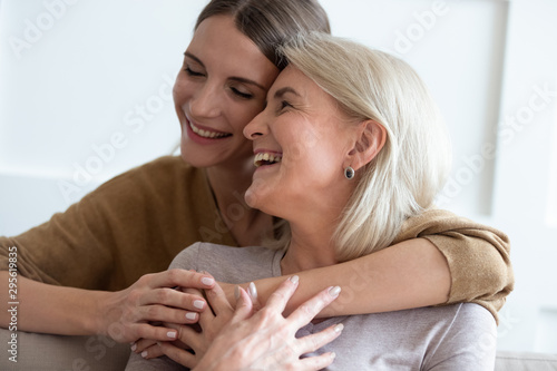 Closeup adult daughter hugs elderly mother enjoy tender moment photo