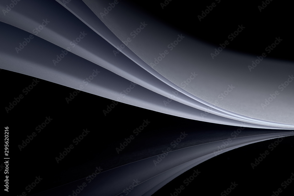 curved white sheets of paper against a dark background curved white sheets of paper against a dark background