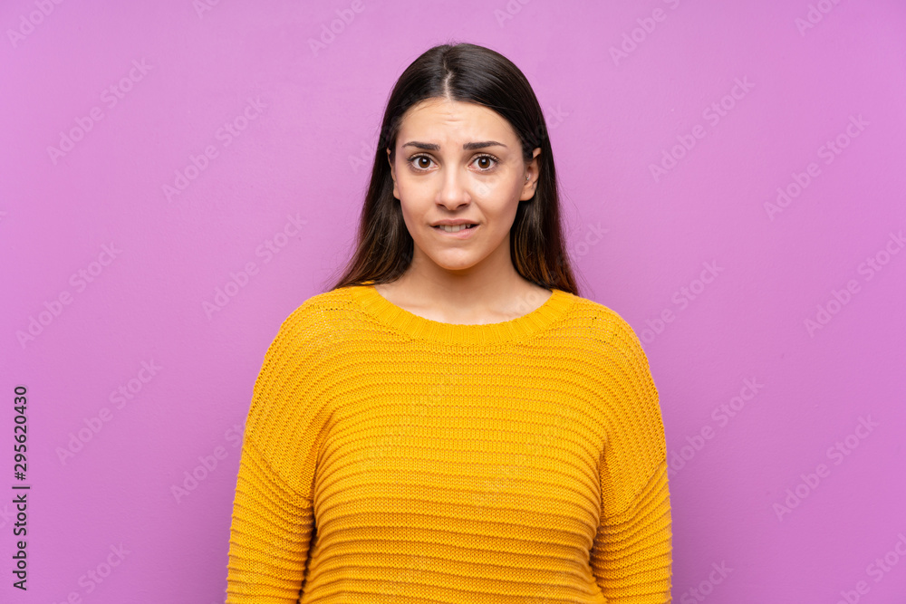 Young woman over isolated purple background having doubts and with confuse face expression Young woman over isolated purple background having doubts and with confuse face expression