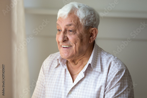 Elderly man looking out the window enjoy sunny day