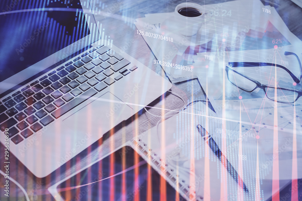 Obraz premium Stock market graph on background with desk and personal computer. Multi exposure. Concept of financial analysis.
