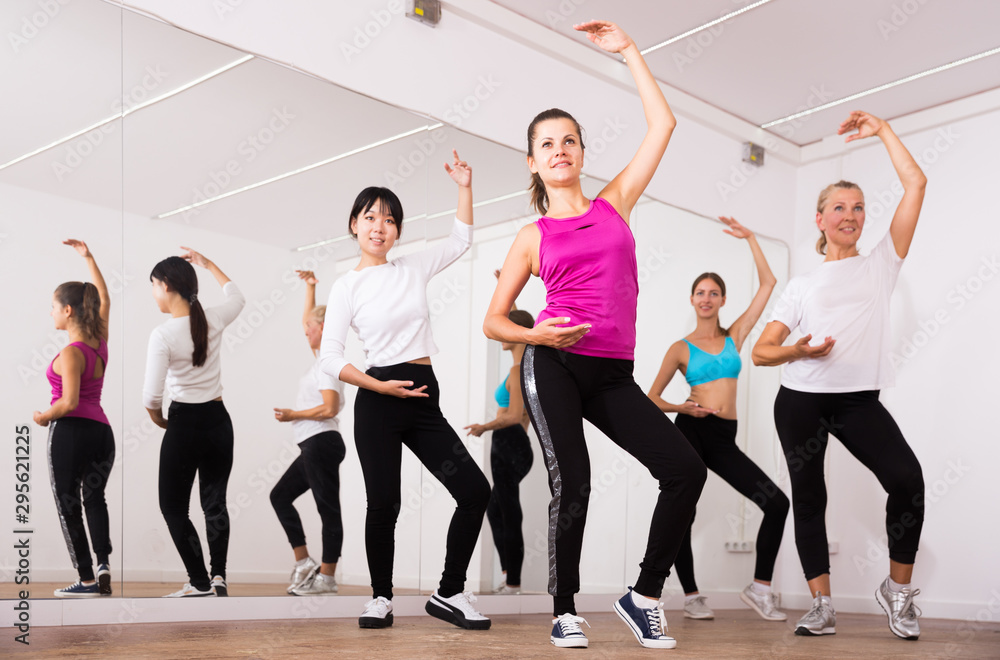 Cheerful different ages women learning swing steps at dance class