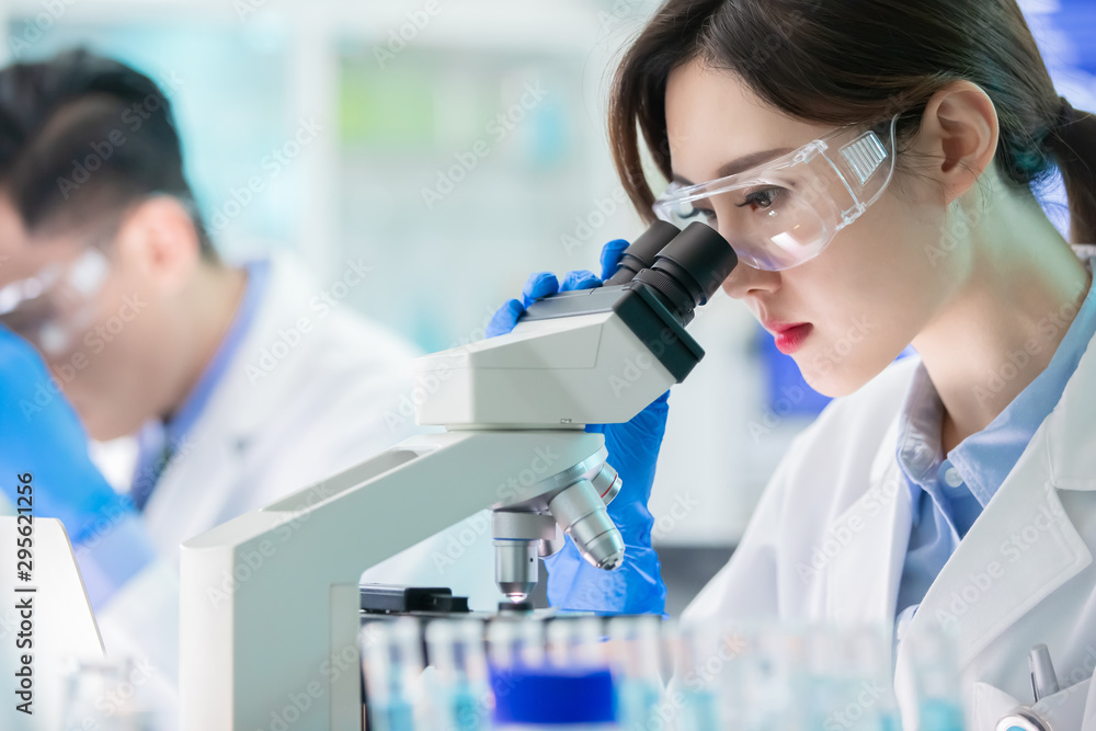 Asian scientist use microscope Asian scientist use microscope