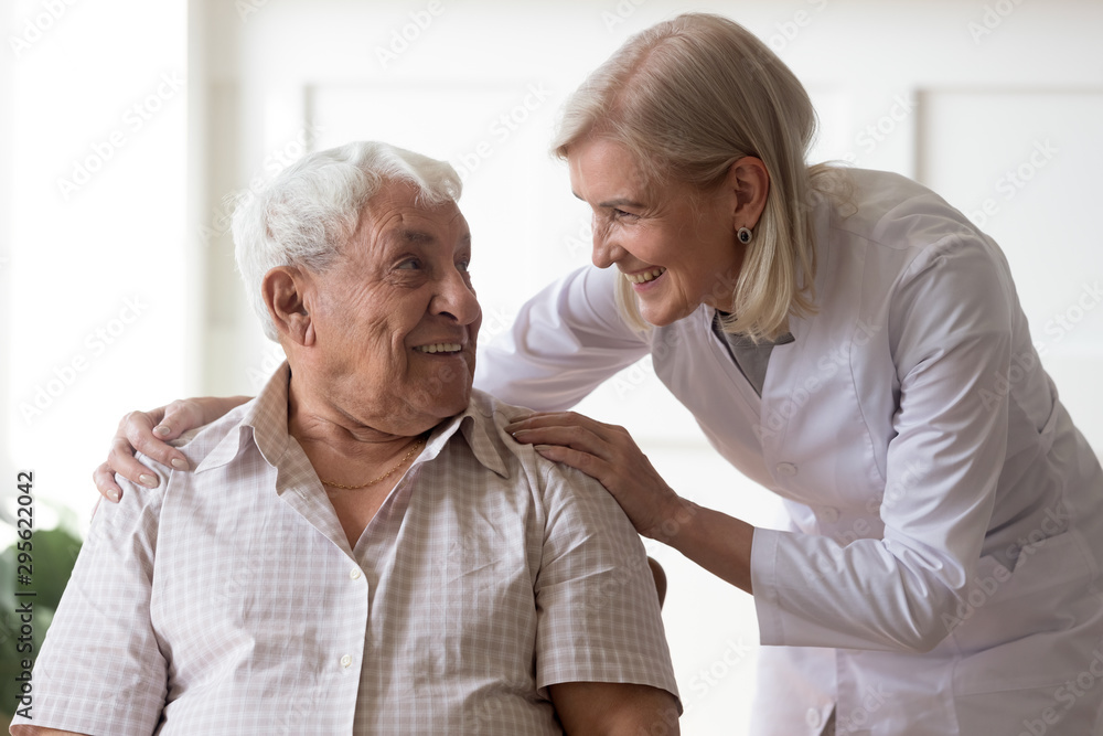 Senior man clinic patient interacting with nurse in white coat Senior man clinic patient interacting with nurse in white coat