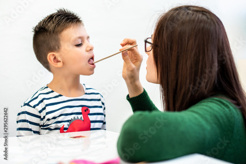 Children speech therapy concept. Preschooler practicing correct pronunciation with a female speech therapist. photo