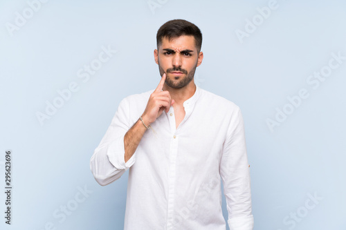 Handsome man with beard over isolated blue background Looking front