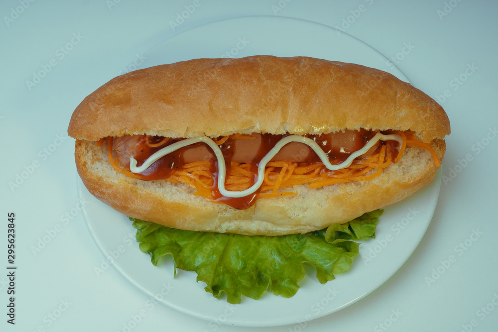 A delicious hot dog with a Korean carrot and spices on a salad leaf. Fast food A delicious hot dog with a Korean carrot and spices on a salad leaf. Fast food