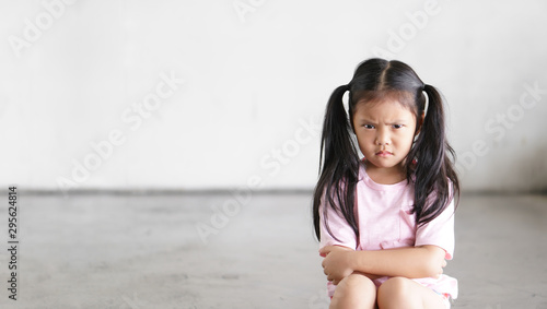 Fotografie, Obraz Asian child cute touchy or kid girl sitting face frown and angry aggressive with