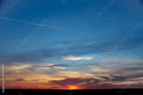 Gentle sky at sunset with contrails from airplane