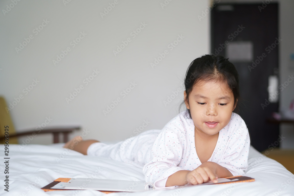 asian child cute or kid girl lie down or sleep to enjoy reading story or diary and school book for read learning on white bed and happy at bedroom or library home and nursery in morning for education asian child cute or kid girl lie down or sleep to enjoy reading story or diary and school book for read learning on white bed and happy at bedroom or library home and nursery in morning for education