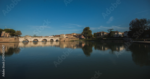 Rimini, Italy - September 11, 2019: Tiberius bridge in Rimini on a background of blue sky with white clouds