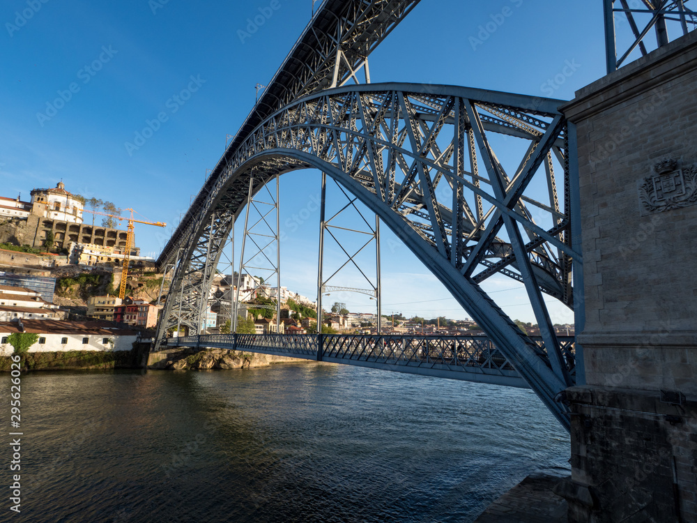 Naklejka premium Portugal, may 2019: Porto view of Dom Luis Bridge at sunset. Porto. Cityscape of Porto downtown touristic Ribeira