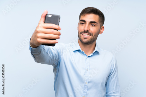 Young handsome man with his mobile making a selfie © luismolinero