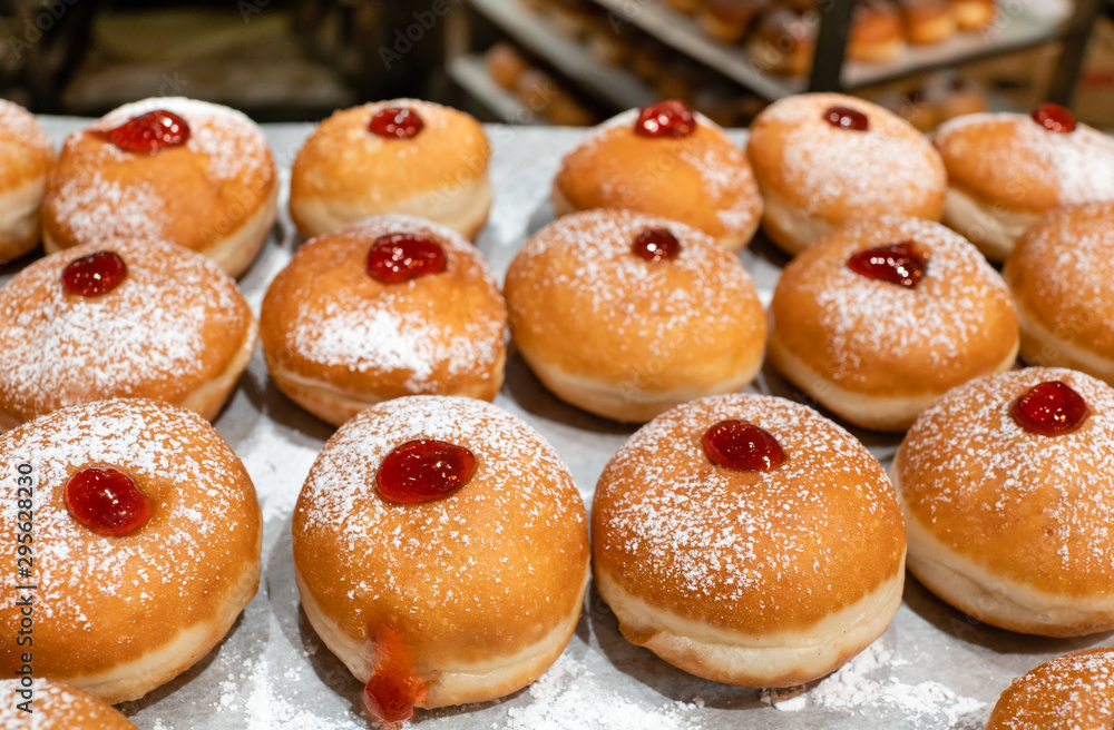 Fresh donuts  with jelly at the bakery display for Hanukkah celebration. Selective focus.