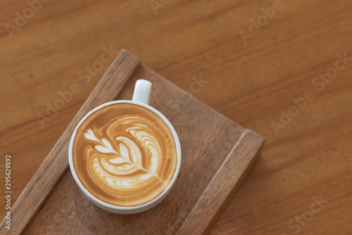 Nice heart tree shape of hot latte art serve on vintage wooden plate
