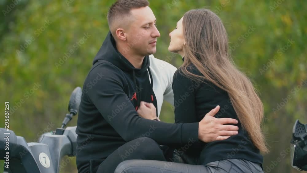 couple kisses standing on ATVs couple kisses standing on ATVs
