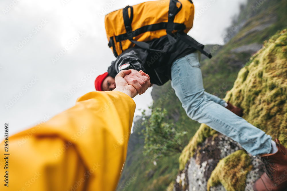 POV view on brave tourist helping his active friend holding to hand climbing to rock. Two travelers climb to mountains lifestyle outdoor vacation POV view on brave tourist helping his active friend holding to hand climbing to rock. Two travelers climb to mountains lifestyle outdoor vacation