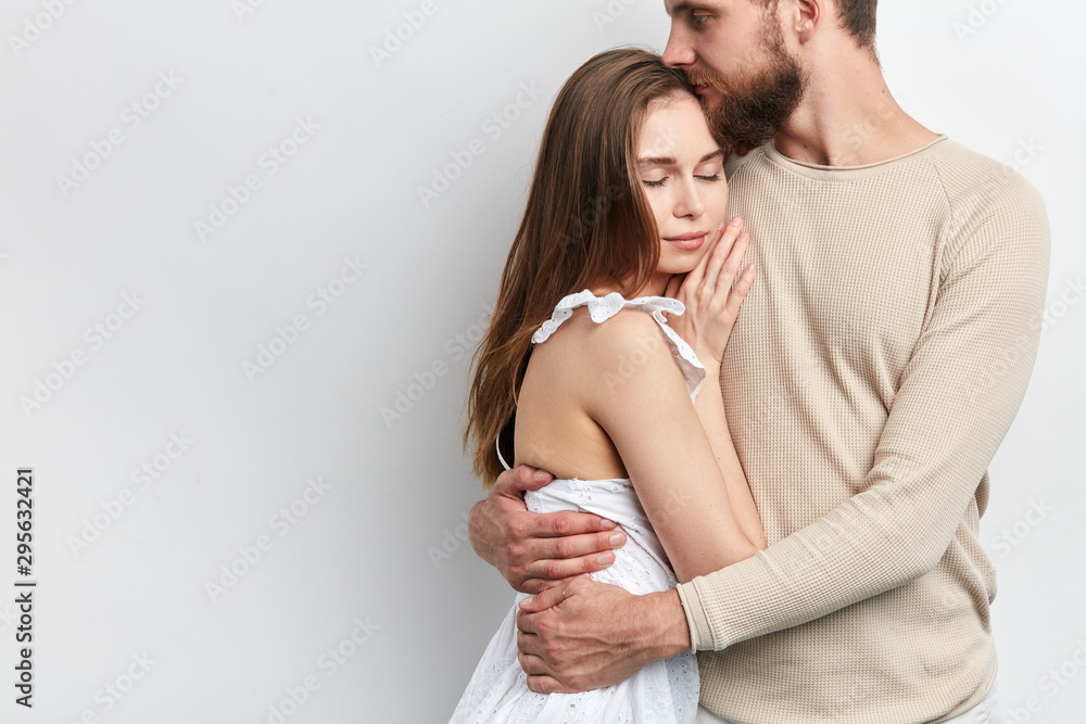 man is hugging his wife, holding in tighet hug, close up cropped phdoto. tender feeling and emotion . copy space, isolated white background man is hugging his wife, holding in tighet hug, close up cropped phdoto. tender feeling and emotion . copy space, isolated white background
